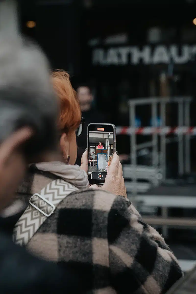 Eine Frau fotografiert mit ihrem Smartphone.