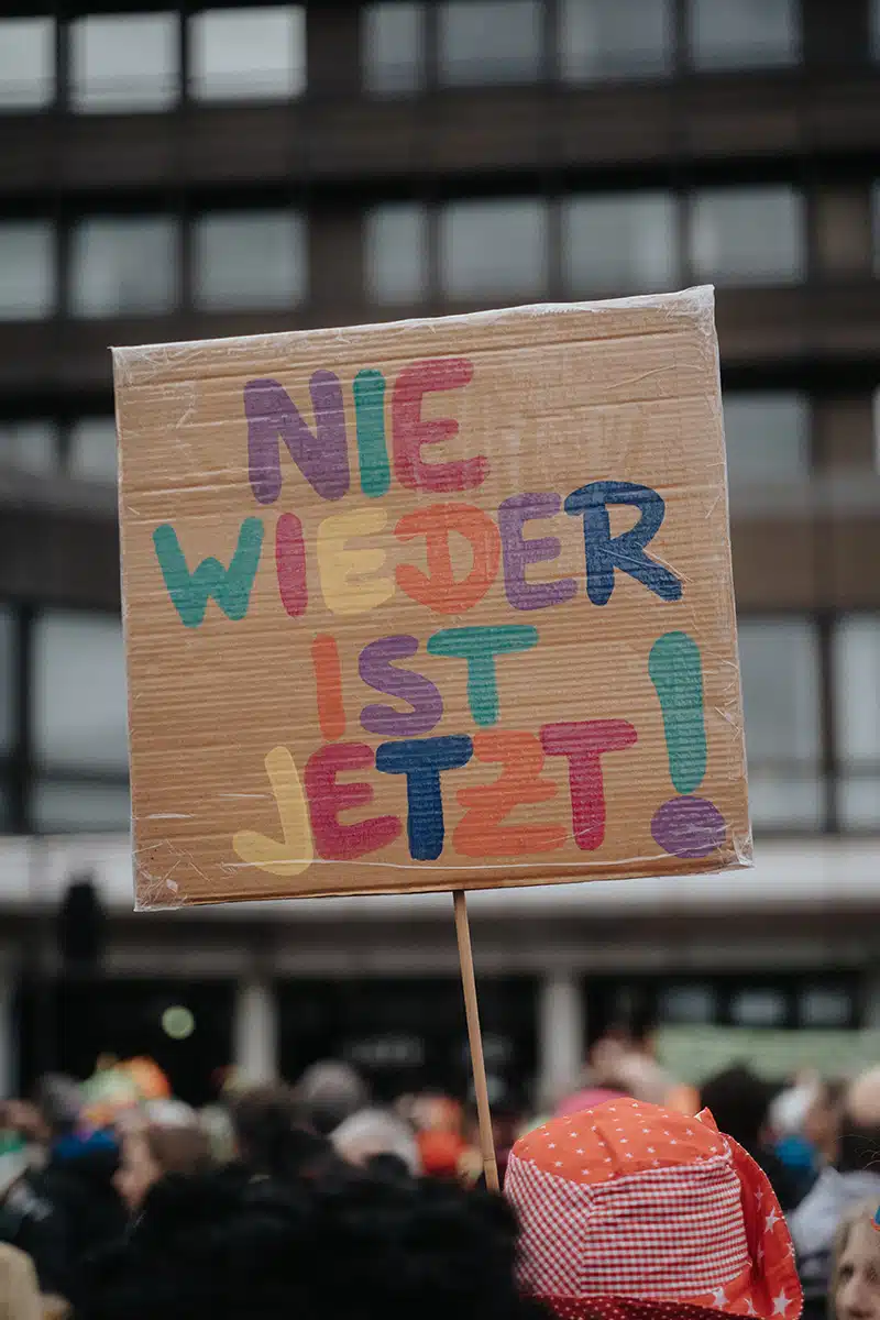 Ein Pappschild mit dem Text "Nie wieder ist jetzt"