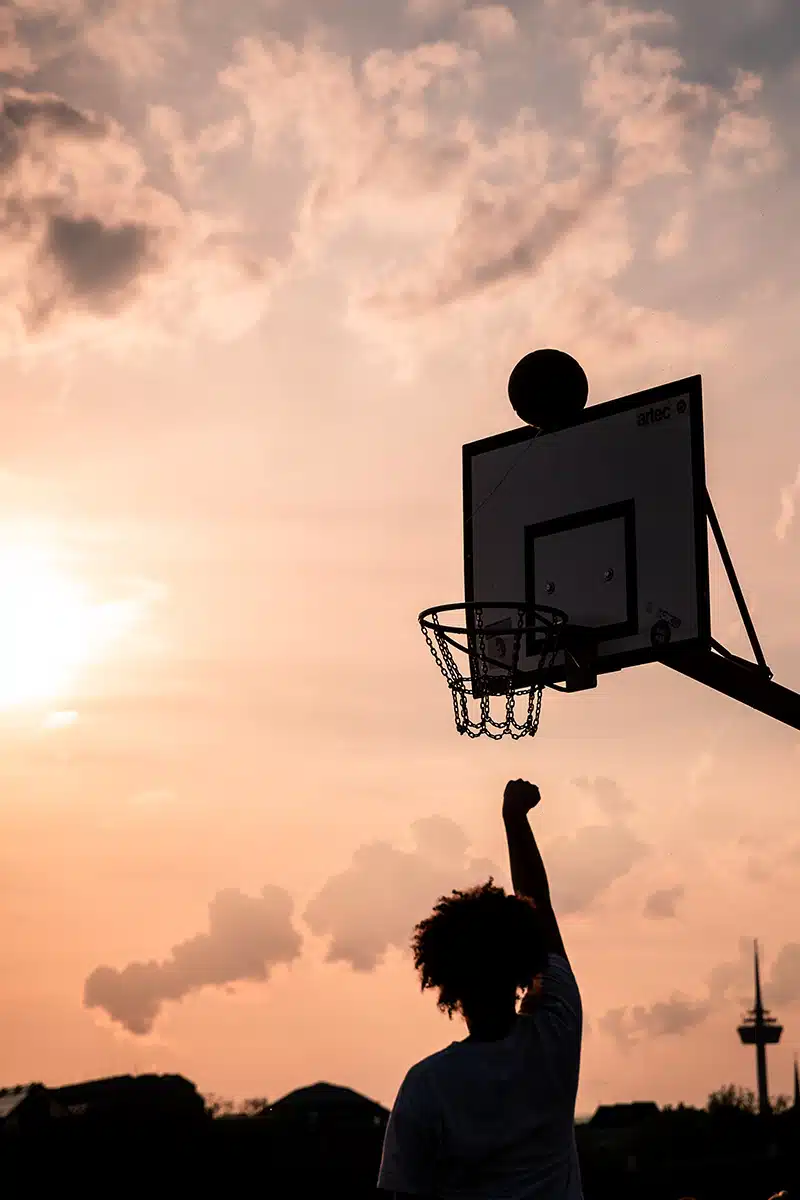 Silhouette einer Person die Basketball spielt.