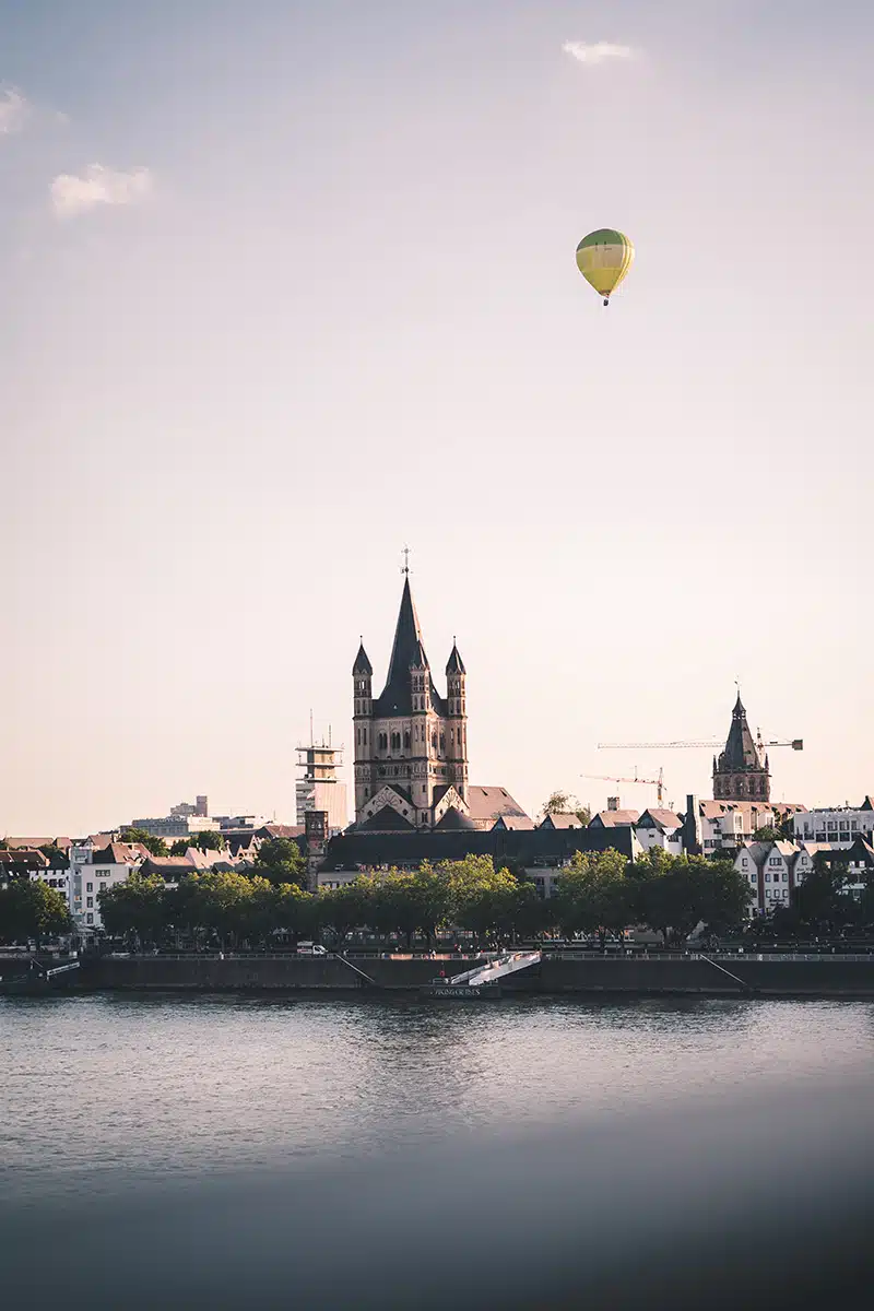 Ein Heißluftballon fliegt über der Kirche Groß St. Martin in Köln.