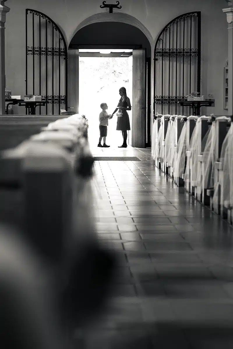 Zwei Kinder stehen als Blumenkinder in der Tür der Kirche.