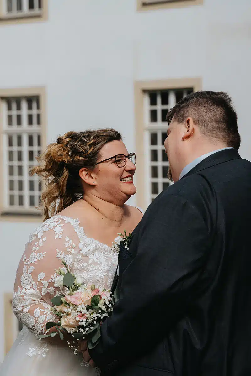 Ein Hochzeitspaar steht sich gegenüber in einem Parkt in Essen, SChloss Borbeck.