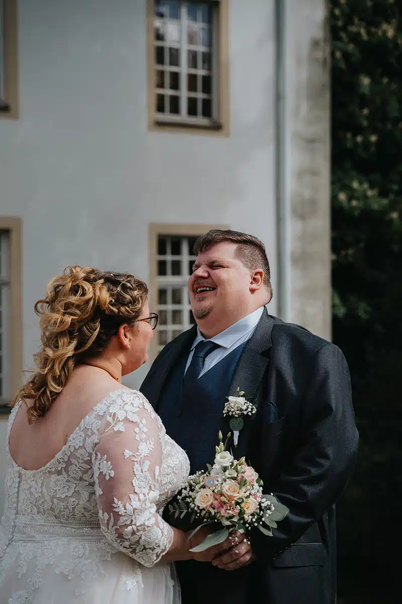 Ein Hochzeitspaar steht sich gegenüber in einem Parkt in Essen, SChloss Borbeck.