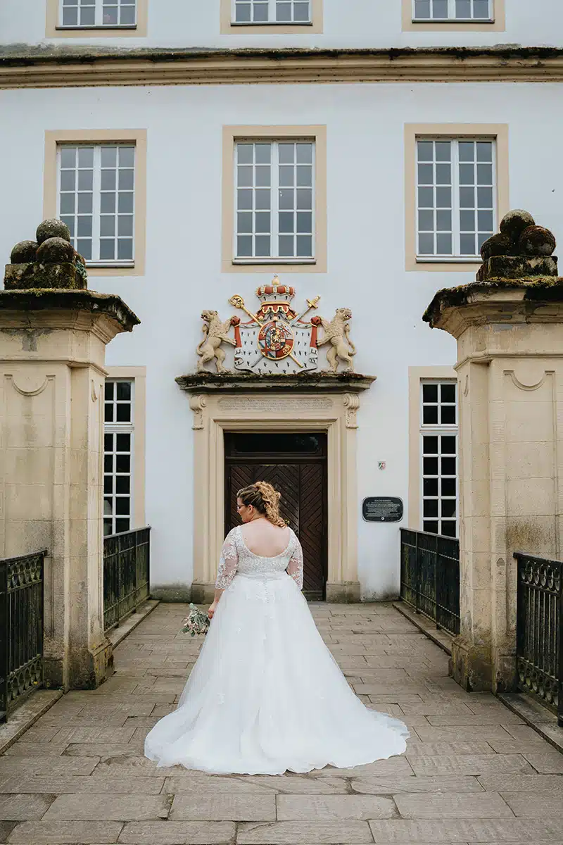 Eine Braut steht vor dem Standesamt in Schloss Borbeck.