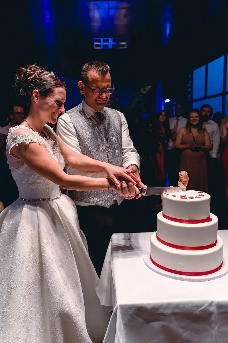 Braut und Bräutigam schneiden die Hochzeitstorte an.