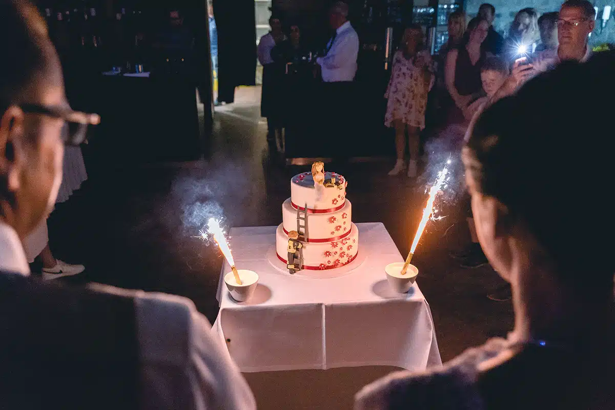 Braut und Bräutigam sehen die Hochzeitstorte an.