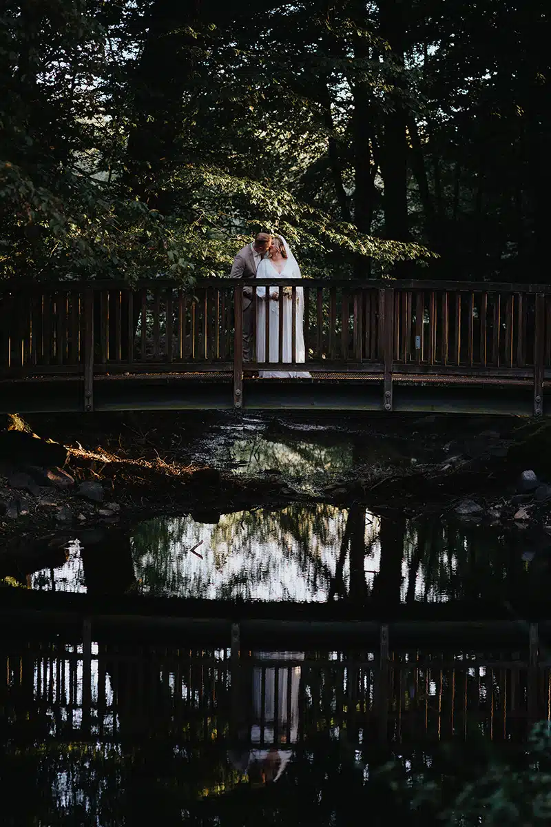 Braut und Bräutigams stehen auf einer kleinen Brücke beim First Look Shooting auf der Burg Wissem.