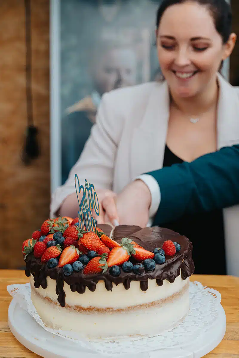 Braut und Bräutigam schneiden eine Torte an.