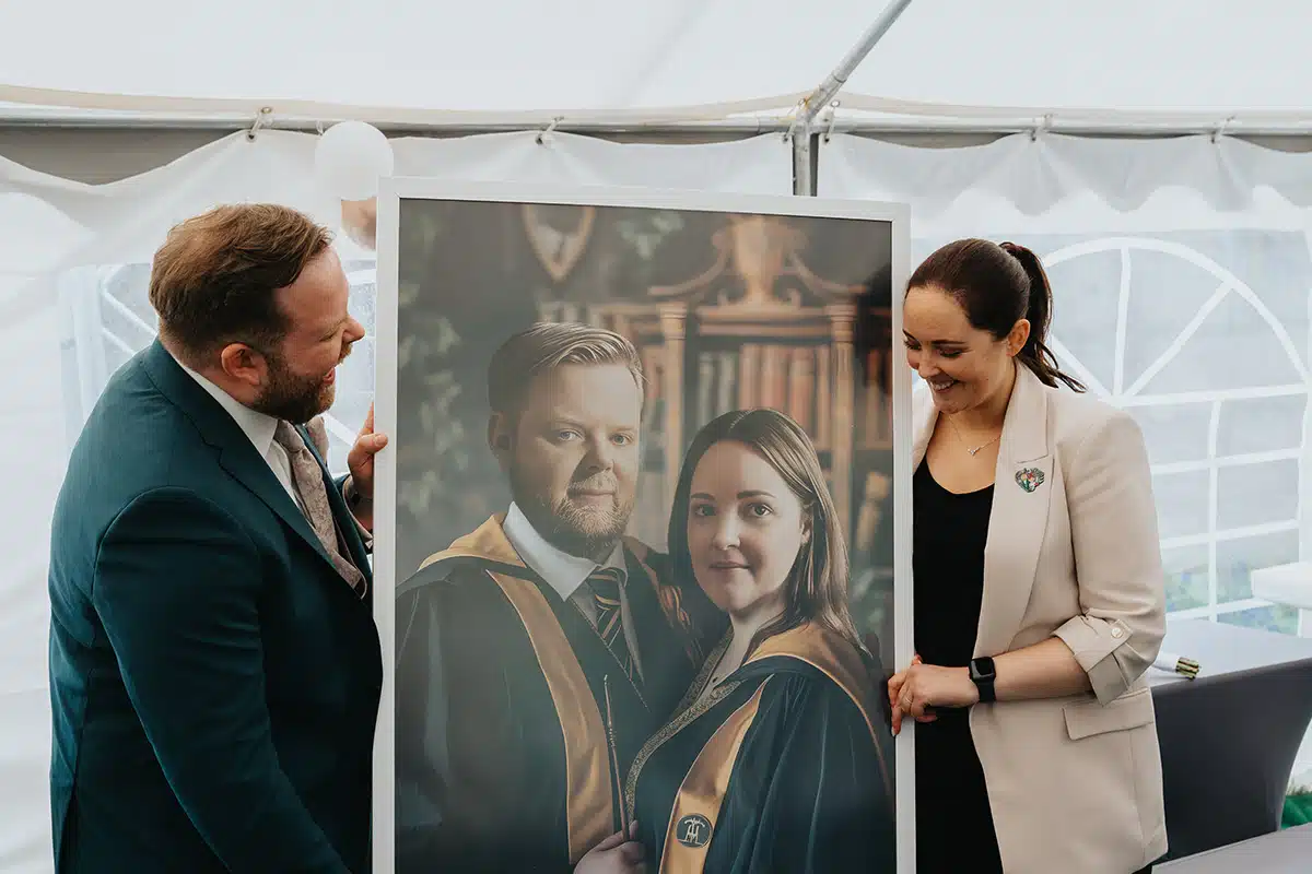 Braut und Bräutigam schauen lachen auf ein großes Portrait im Harry Potter Stil.