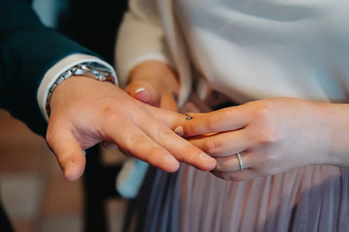 Die Braut steckt dem Bräutigam den Ring an seinen Finger.