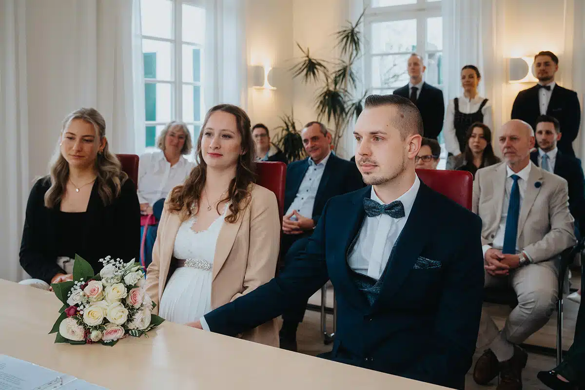 Das Brautpaar sitzt im Standesamt.