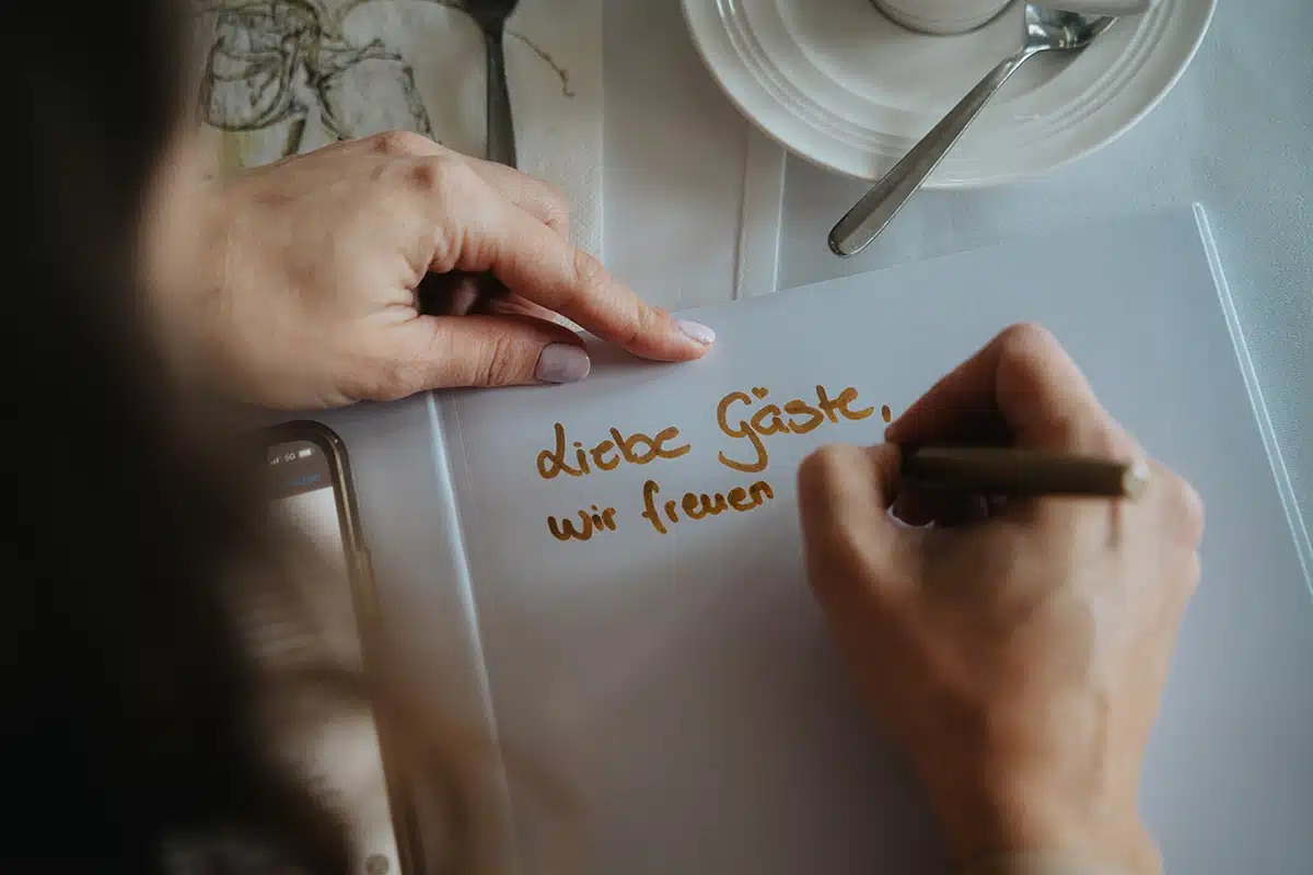 Die Braut schreibt in das Gästebuch.
