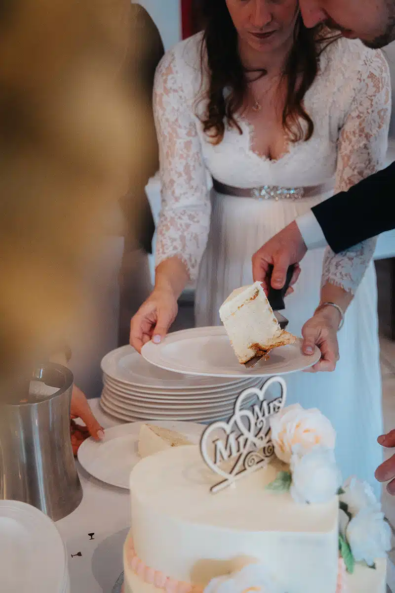 Braut und Bräutigam verteilen Hochzeitstorte.