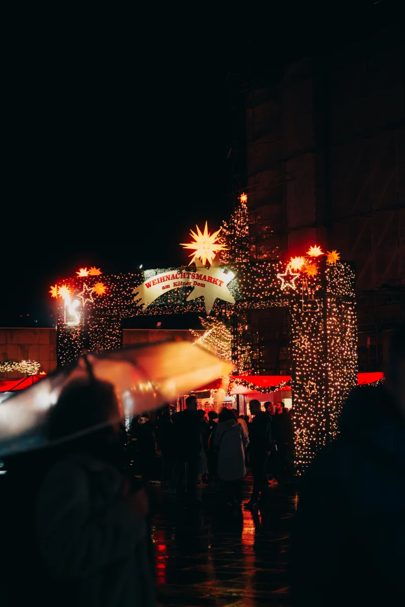 Das beleuchtete Eingangstor zum Weihnachtsmarkt am Kölner Dom.