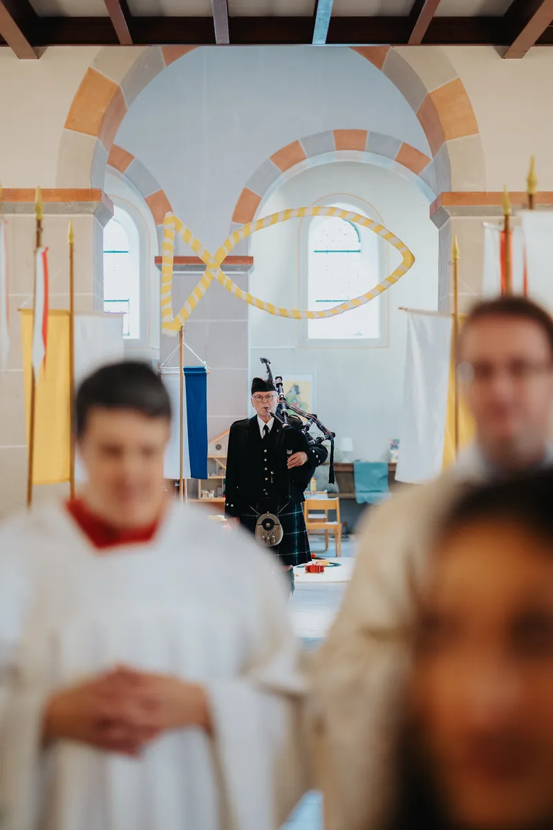 hochzeitsfotograf-neunkirchen-seelscheid-hochzeitsfotograf-philipp-wildfeuer-132 Der Dudelsackspieler wird aus der Perspektive der Priesterbank aufgenommen; festgehalten vom Hochzeitsfotograf Neunkirchen‑Seelscheid.