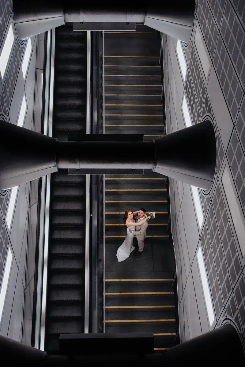 standesamt-fotograf-koeln-philipp-wildfeuer-hochzeitsfotograf-117 Künstlerisches Foto des Brautpaares auf einer modernen Treppe in Köln – Kontrast zwischen Architektur und Emotion. (Standesamtliche Trauung Rentkammer Köln, Philipp Wildfeuer -Hochzeitsfotograf)